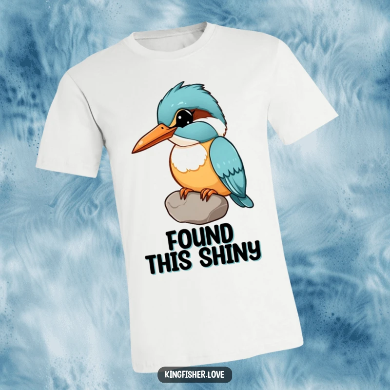 Funny T-shirt featuring a kingfisher holding a shiny pebble in its beak, head tilted curiously, showing off a found treasure.